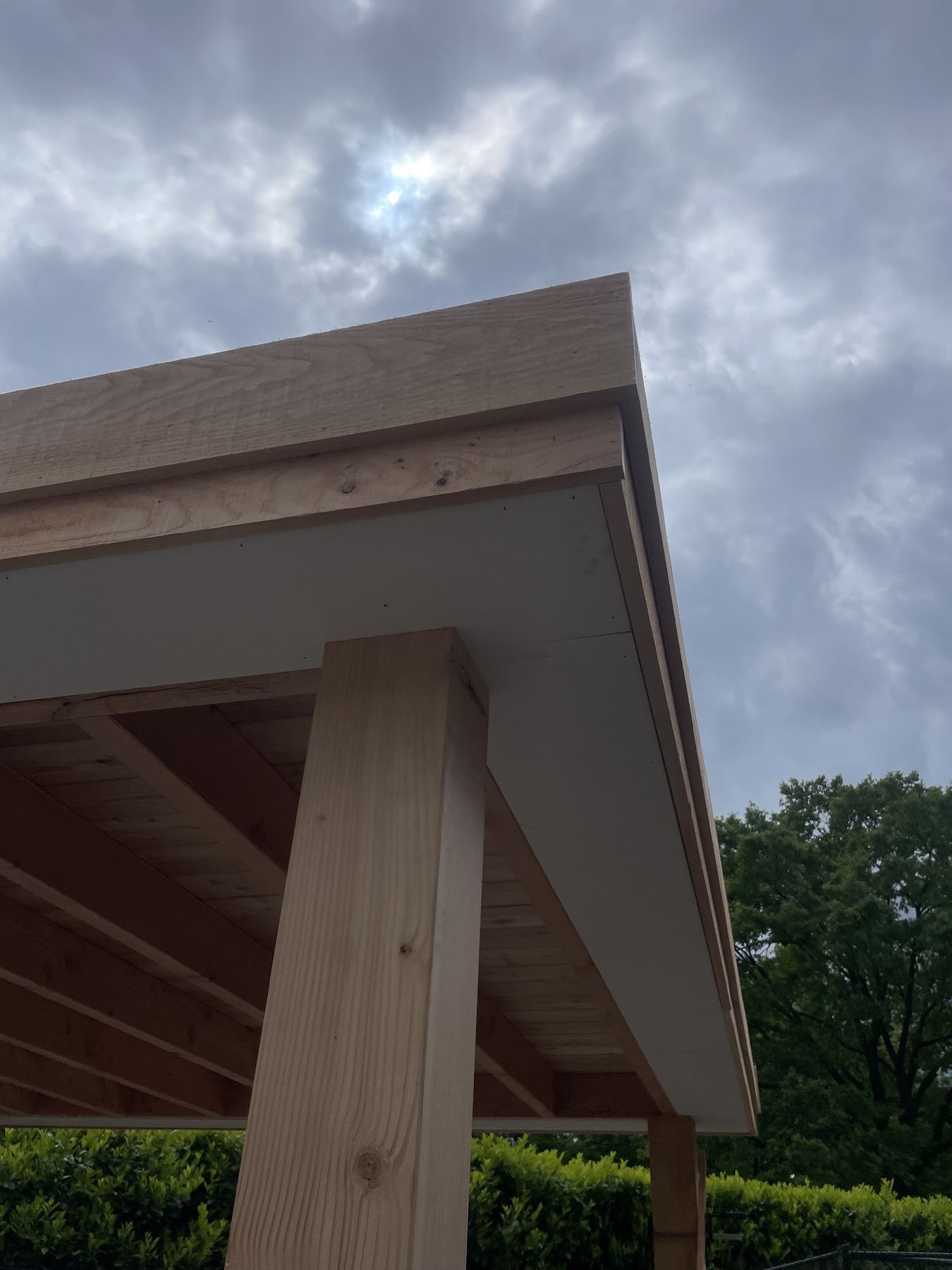 Onderaanzicht van een houten overstek met boeiboord en staander