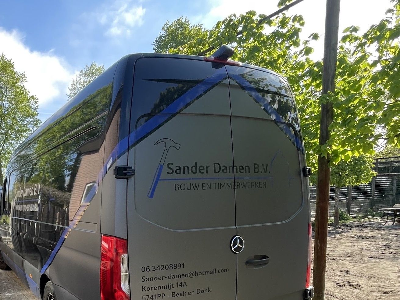 De bedrijfsbus van Sander Damen B.V. met de belettering Bouw en timmerwerken